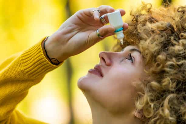 women using eye drops to relief its eye dryness