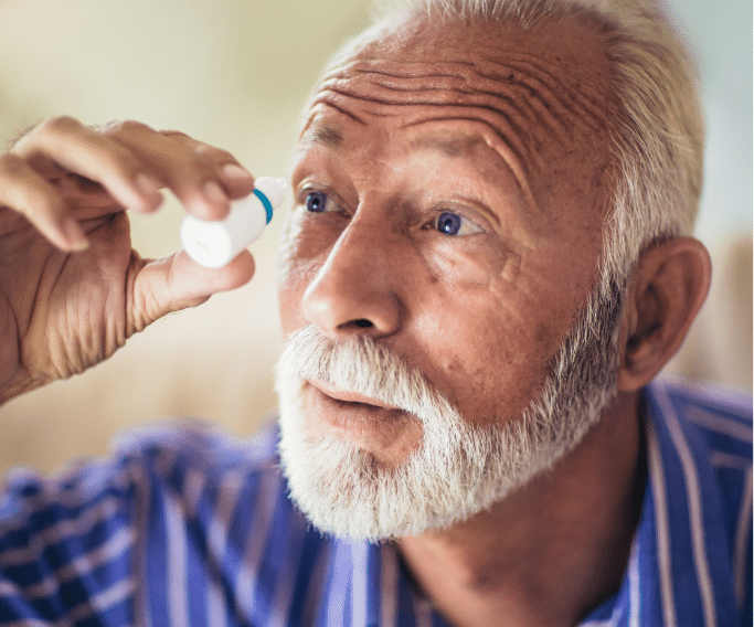 Old man using eyedrops 