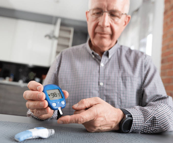 Old man using glucose meter 