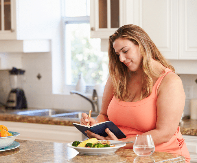 An obese woman making a diet plan 