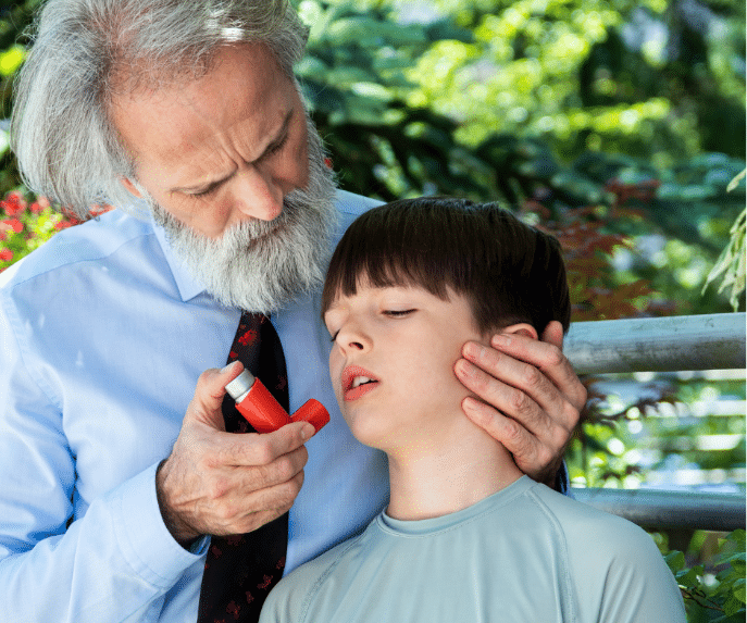 Old man helping a boy use his inhaler 